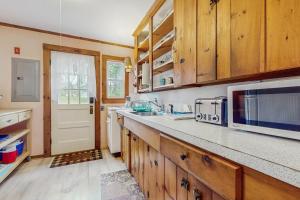 a kitchen with wooden cabinets and a counter top at Uncle Rolfs Cozy Cottage in Dennis Port