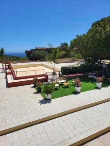 a park with benches and tables and potted plants at Bilocale presso Costa Smeralda in Cugnana Verde