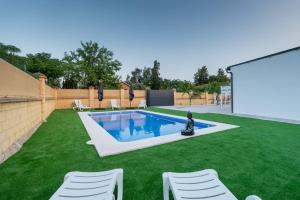 a backyard with a pool and green grass at Resort Circuito Sevilla in Carmona