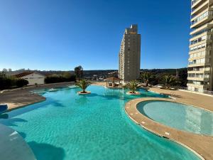 维纳德马Comodo Depto con hermosa vista的一个大型游泳池，背景是一栋建筑