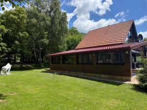 a small house with a grassy yard in front of it at Holiday House Vale Verde in Korenica +10 photos