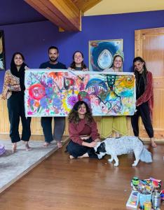 マナリにあるSehar Boutique Stay & Galleryの犬と一緒に大きな絵を掲げている人々のグループ