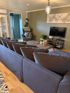 a living room with a row of leather couches at Åskollen, Drammen in Drammen