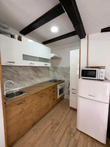 a kitchen with a white refrigerator and a sink at Holiday House Vale Verde in Korenica