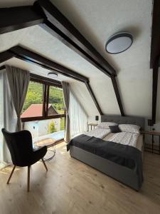 a bedroom with a bed and a chair and a window at Holiday House Vale Verde in Korenica