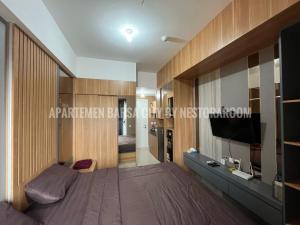 une chambre avec un lit et une télévision à écran plat dans l'établissement Apartemen Barsa City ByNestoraroom, à Seturan