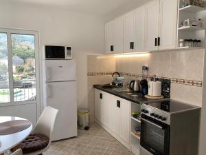 a kitchen with white cabinets and a white refrigerator at Apartment Dream Summer 2 -Premium Beach Apartament for 4 in Tivat