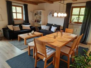 a living room with a wooden table and a dining room at Ferienwohnung AusZeit in Hauzenberg