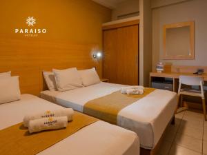 Una habitación de hotel con dos camas y un escritorio. en Hoteles Paraiso CHICLAYO, en Chiclayo