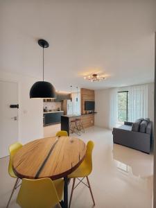 a kitchen and living room with a wooden table and chairs at Apartamento Artsy in Itaipava +13 photos