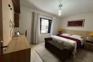 a bedroom with a bed and a couch in it at Casa da Tribo Hospedagem in Bom Jardim da Serra