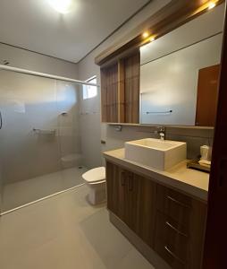 a bathroom with a sink and a toilet and a mirror at Casa da Tribo Hospedagem in Bom Jardim da Serra