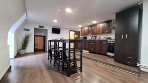 a kitchen with wooden cabinets and a bar with stools at Town Square Loft Apartment in Braşov