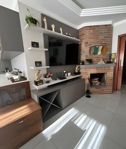 a living room with a fireplace and a desk at Casa da Tribo Hospedagem in Bom Jardim da Serra +12 photos