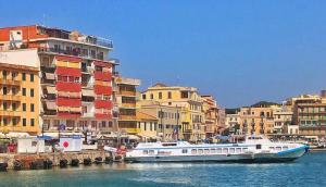a boat in the water in front of buildings at L'Aurora Casa Vacanze in Anzio