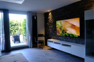 sala de estar con TV en una pared de ladrillo en Garden Apartment, en San Colombano al Lambro