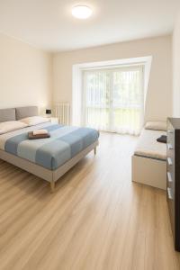 a white bedroom with a bed and a large window at San Siro ippodromo fiera Milano apartment x4pax in Milan