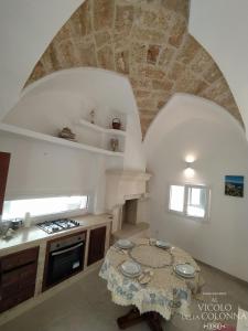 a kitchen with a table and a stone ceiling at Casa Vacanza Al Vicolo della Colonna nel centro storico di Presicce in Presicce