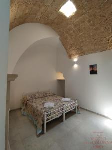 a bedroom with a bed in a white room at Casa Vacanza Al Vicolo della Colonna nel centro storico di Presicce in Presicce