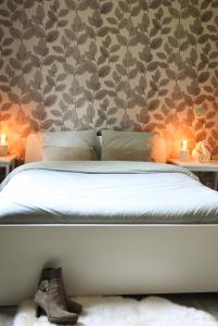 a bedroom with a bed and two tables with candles at Villa de Mamoune in Martelange