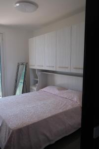 a bedroom with a bed and white cabinets at Nervi, sea view in Genova +17 photos