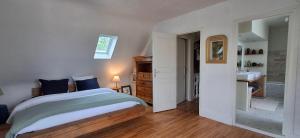 a bedroom with a bed and a bathroom with a sink at Villa de la Mer in Lézardrieux