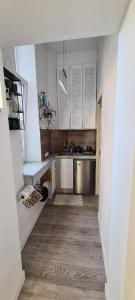 a small kitchen with white cabinets and a sink at Pasta apartment Self-Check-in in Liepāja