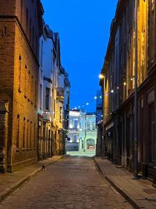 an empty city street at night with buildings at Pasta apartment Self-Check-in in Liepāja