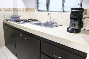 a kitchen counter with a sink and a mixer at Hermoso Apartaestudio, moderno, cercaavdelosestudiantes, apto303 in Pasto