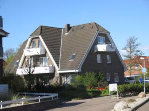a large house with a pitched roof on a street at Laguna-Beach-Büsum in Büsum