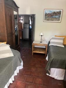 a room with two beds and a table with a lamp at Casa Chica in Cafayate
