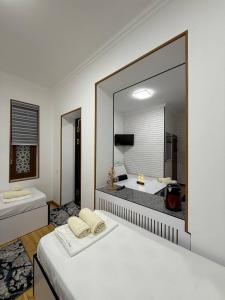 a bedroom with a large mirror and a bed at SumayShakh Guest House in Bukhara