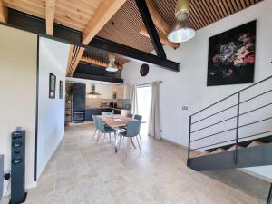 a dining room and kitchen with a table and chairs at Appartement Duplex les Cerisiers - Bilhac in Polignac