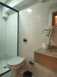a bathroom with a toilet and a sink at Hotel Colonial in Irati