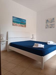 a bed in a white room with a blue mattress at Appartamento G&G in San Vito lo Capo