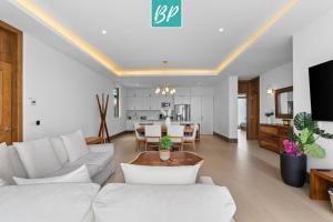 a living room with white furniture and a dining room at QUIYA - Luxury Condos with Exclusive Beach Club in Cruz de Huanacaxtle