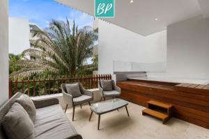 a patio with a couch and two chairs and a piano at QUIYA - Luxury Condos with Exclusive Beach Club in Cruz de Huanacaxtle