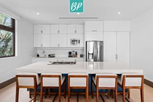 a kitchen with a large white island with stools at QUIYA - Luxury Condos with Exclusive Beach Club in Cruz de Huanacaxtle