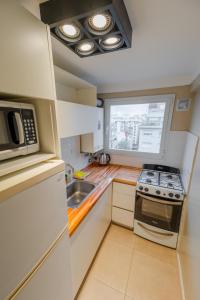 a small kitchen with a stove and a microwave at Check and Home - Entre Ríos - 4 Huéspedes a estrenar a 100 mts Plaza Colón y Casino in Mar del Plata +4 photos