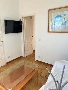 a living room with a glass coffee table and a tv at Atardeceres & Jacuzzi in La Manga del Mar Menor