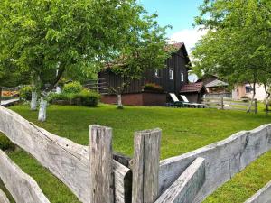 a wooden fence in front of a house at Apartments Novela in Poljanak