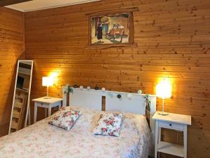 a bedroom with wooden walls and a bed with two tables at Apartments Novela in Poljanak
