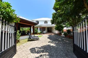 una cerca frente a una casa con un banco en Jessies Guest House Seychelles, en Beau Vallon