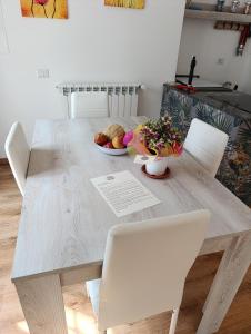 a wooden table with chairs and a bowl of fruit at Il Giardino Fiorito in Trevignano Romano