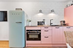 a pink and white kitchen with a refrigerator at Ankerplatz SPO 2 in Böhl