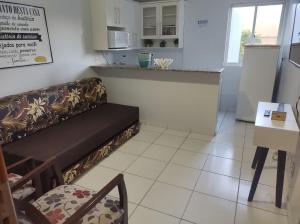 a living room with a couch and a kitchen at Flat de 1 Qto Golden Dolphin Roberto Imóveis in Caldas Novas
