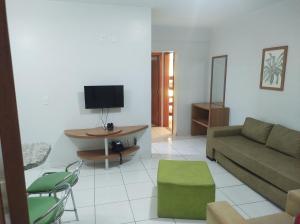 een woonkamer met een bank en een tv bij flat 2 qtos Golden Dolphin Roberto Imoveis in Caldas Novas