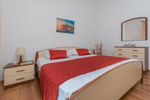 a bedroom with a bed with a red blanket and a mirror at Apartment Green view in Slime +23 photos