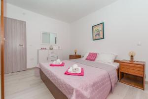 a bedroom with a pink bed with two towels on it at Apartment Green view in Slime