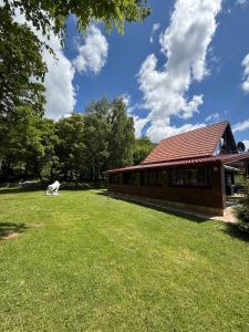 a building with a grassy yard next to a building at Holiday House Vale Verde in Korenica